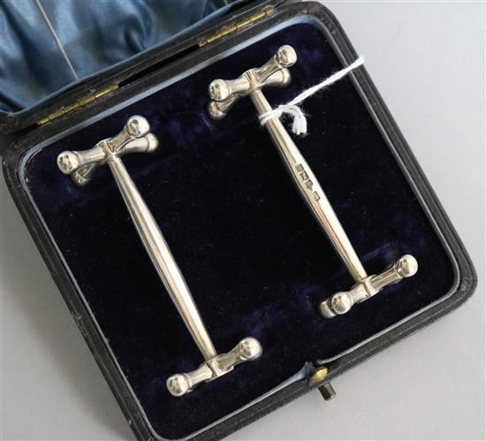 A cased pair of silver knife rests, George Howson, Sheffield, 1909/1910, 78mm.